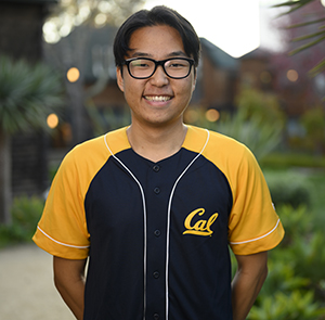Elbert Moon, wearing a Cal t-shirt, smiles for the camera. He is a senior and a Golden Bear Orientation student coordinator.