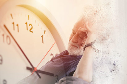 Old man with Alzheimer's next to giant clock.
