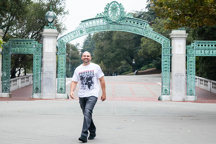 Kevin McCarthy, a new transfer student who was incarcerated for most of his ilfe, walks past Sather Gate wearing a smile and a T-shirt protesting racial injustice