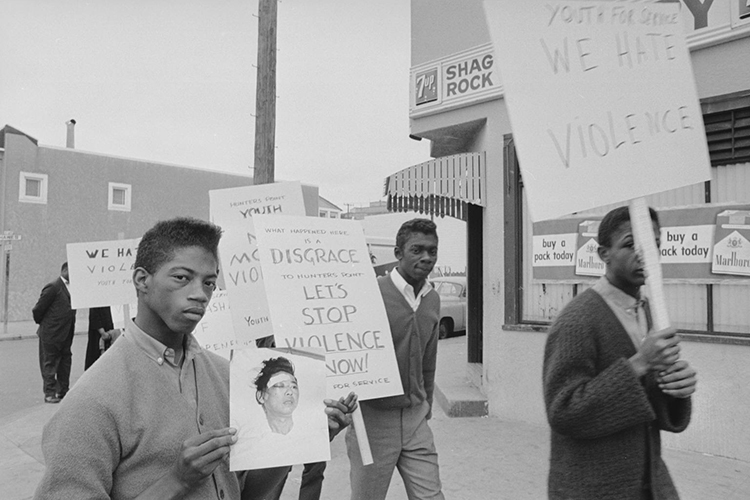 Three Black boys hold protest signs in 1964 against racial violence