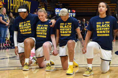Women's basketball players kneeling during the national anthem