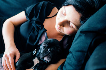 woman sleeping on a couch with a dog