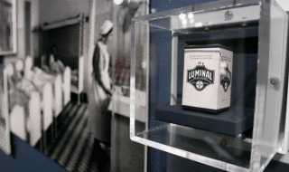 A photo of a tin container labeled "Luminal" behind a glass case as part of a museum exhibit