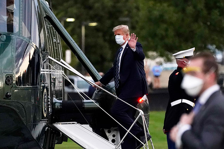 A photo of President Donald Trump, wearing a mask, on the steps into Marine One.