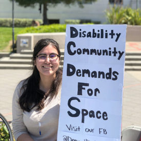 alena morales holds a sign that reads "disability community demands for space"