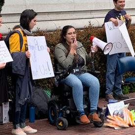 alena morales holds a megaphone at a protest