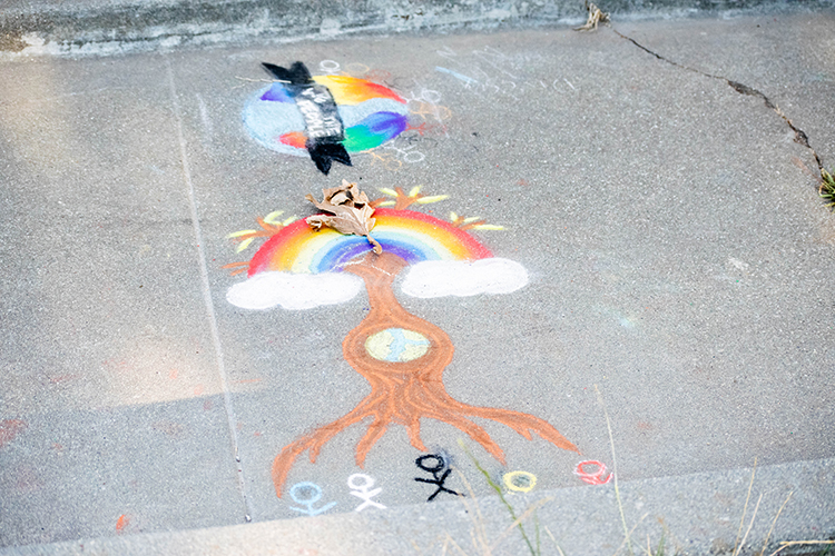 chalk drawing of a rainbow connected to a tree