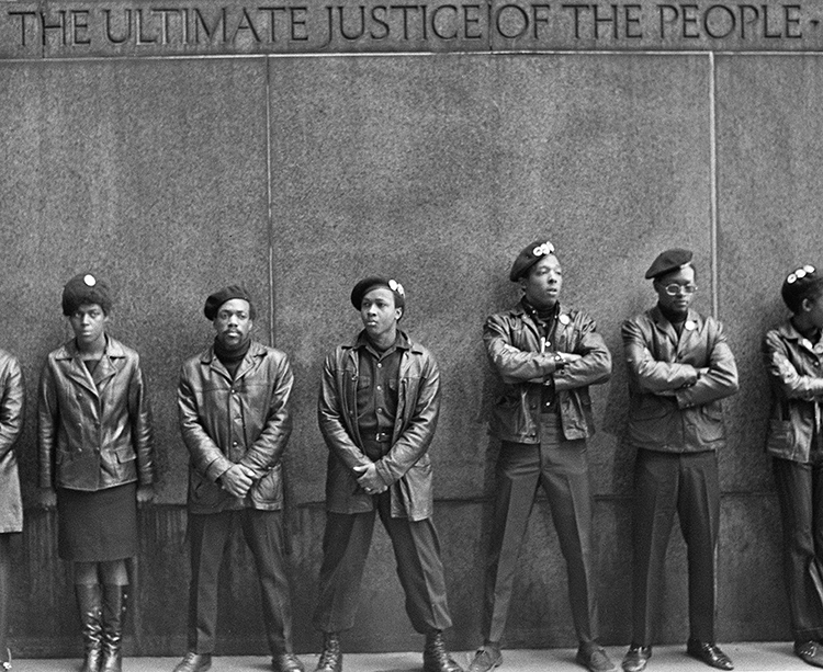 memebrs of the black panther party standing on a wall