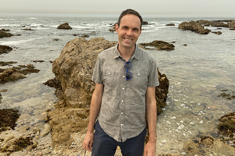 Alec Barrows, the great-great-grandson of David Barrows, former UC president, stands on a beach in Monterey.