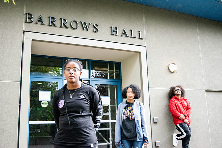 Three African American members of the campus community stand in front of an entrance to Barrows Hall, which was unnamed by campus officials on Nov. 18. Pictured are Melissa Charles, a staff member, Kyra Abrams, a student, and Blake Simons, a student.
