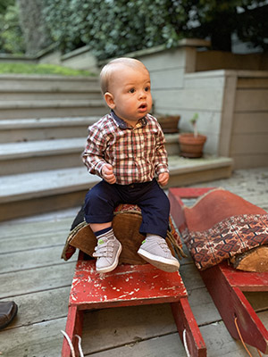 The great-great-great-grandson of former UC President David Barrows sits on a red wooden sled made by Barrows decades ago.