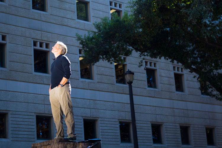 A photo of Dacher Keltner standing in a beam of sunlight.