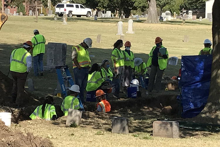 In October 2020, a team of experts in day-glo vests works in a Tulsa, Oklahoma cemetery where at least some of the bodies from the 1921 Tulsa Race Massacre are believed to have been hastily buried.