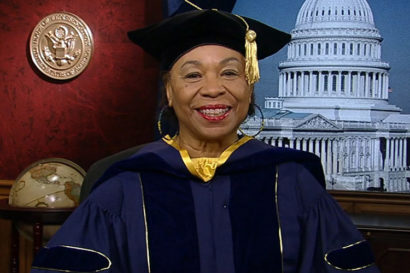 Barbara Lee smiling with graduate regalia on