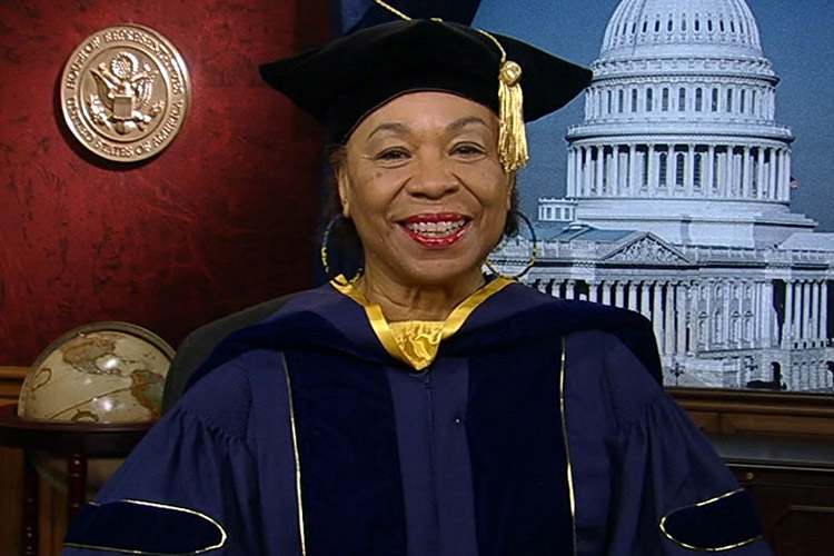 Barbara Lee smiling with graduate regalia on