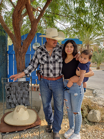 Dalia Rangel Perez, a first-year student at Berkeley, poses outside her famliy's home in Coachella Valley with her father and 6-month-old nephew.