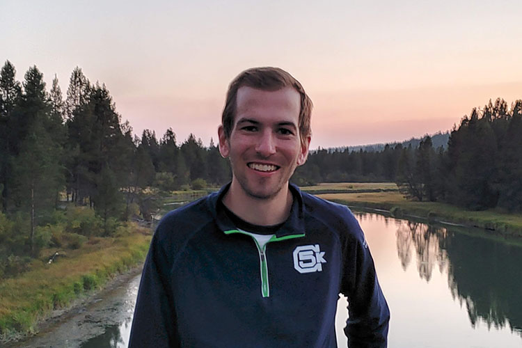 Kevin Frazier smiling in front of a creek