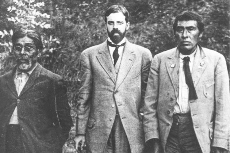 A black and white photo from 1911 of UC anthropologist Alfred Kroeber; Sam Batwai, a translator of the Yahi language; and a Native American man named Ishi. All three men are wearing suitcoats and ties.