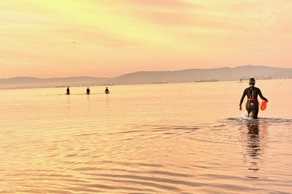 Laura Counts, in her wetsuit, joins friends in the bay off Alameda at sunrise.