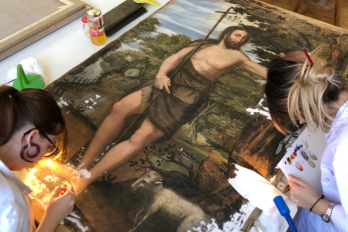 Two women fixing up a painting of St. John the Baptist