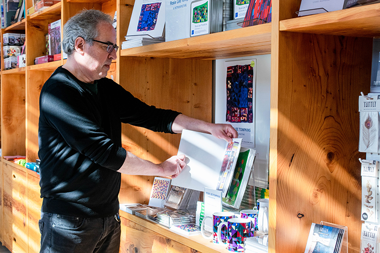 Jim Sugarman, the sales and admissions manager for the Berkeley Art Museum, shows merchandise in the museum store related to the exhibit 