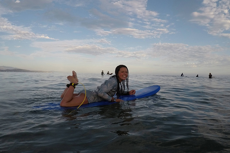 Lying on her surfboard, Katia Gibson poses in the water near the UC Santa Barbara campus