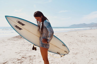 Surfer Katia Gibson poses with her surfboard at Emma Wood State Beach off Ventura Highway
