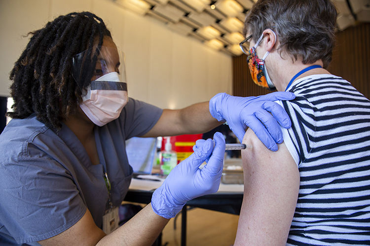 A senior scientist at Lawrence Berkeley Lab, Frances Houle, receives a vaccine at Pauley Ballroom.