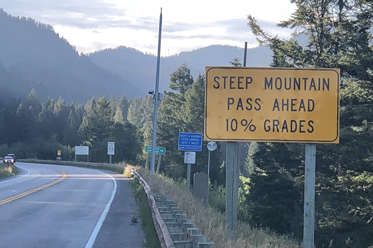 A sign on the road through the Teton Range of the Rocky Mountains warns of a steep moutain passage, the one in which Professor Emeritus had a bike accident in August 2019. The sign reads steep mountain pass ahead 10% grades.