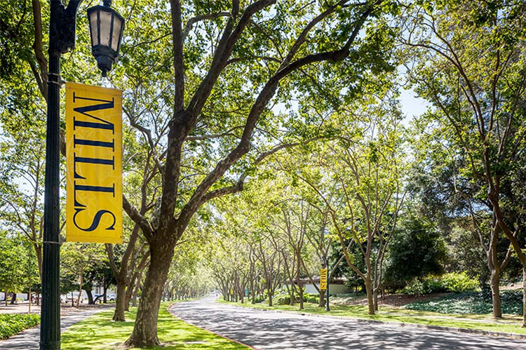 A banner that says Mills College hangs near rows of trees on the Mills College campus, where Berkeley will have its first-ever first-year residential program for incoming students in fall 2021