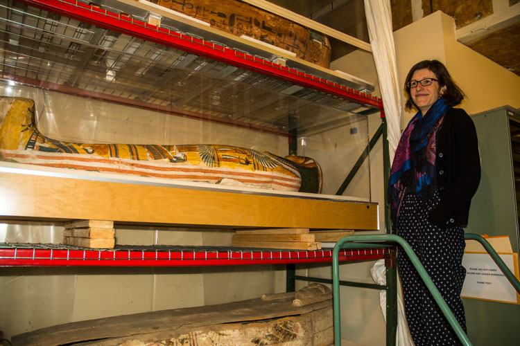 Lauren Kroiz, director of the Hearst Museum, stands next to three Egyptian sarcophagi in the basement of the Anthropology and Art Practice Building.