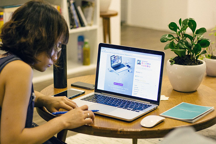 A woman works alone at home before a laptop computer