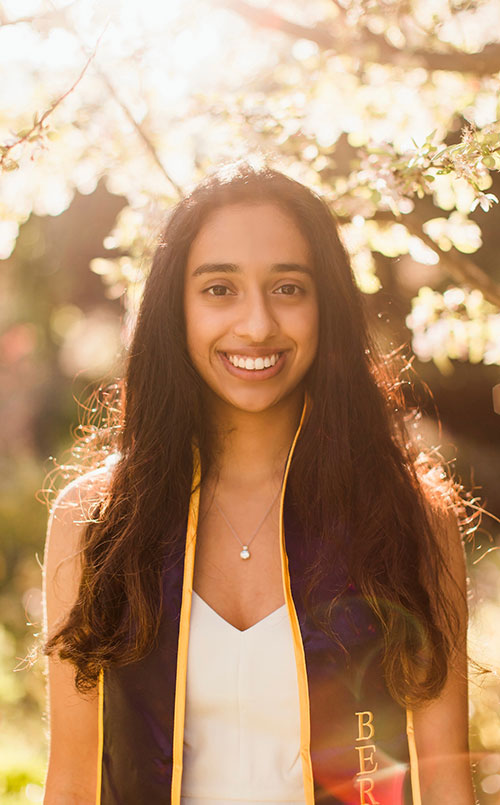 Manasi smiling wearing a Berkeley graduation sash