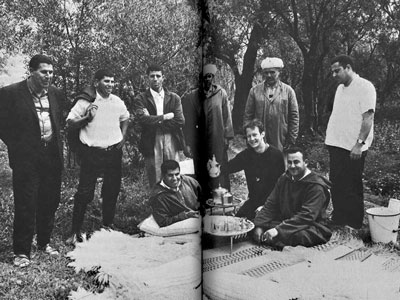 Rabinow holds up tea pot while surrounded by a group of six men in Morocco.