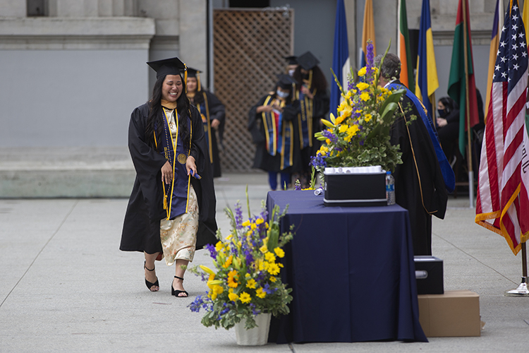 Anna Nguyen, a Master of Social Welfare graduate, laughs and cries as she walks across the stage during the first day of UC Berkeley's socially distanced graduation ceremony at the Greek Theater