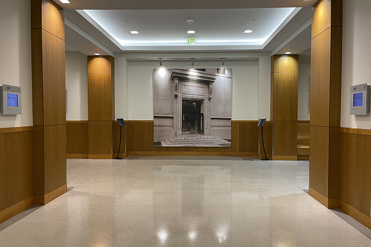 A photo of the first-floor hallway in Berkeley Law's North Addition and the lithograph of Boalt Hall's first home, in today's Durant Hall. The lithograph was taken down to make way for the new Boalt Hall historical display.