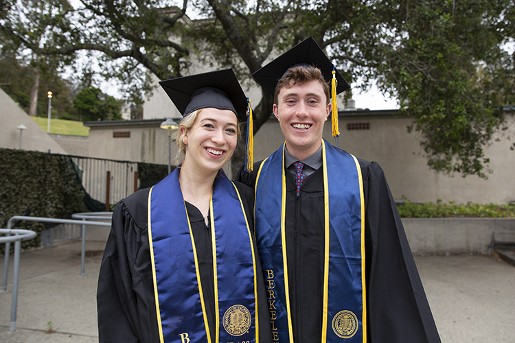 Partners Charlotte Buck and Peter Lopitz pose for a photo at the Greek Theatre wearing their regalia and blue stoles.