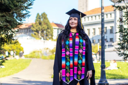 Daniela Medina wearing her graduation gown on campus.