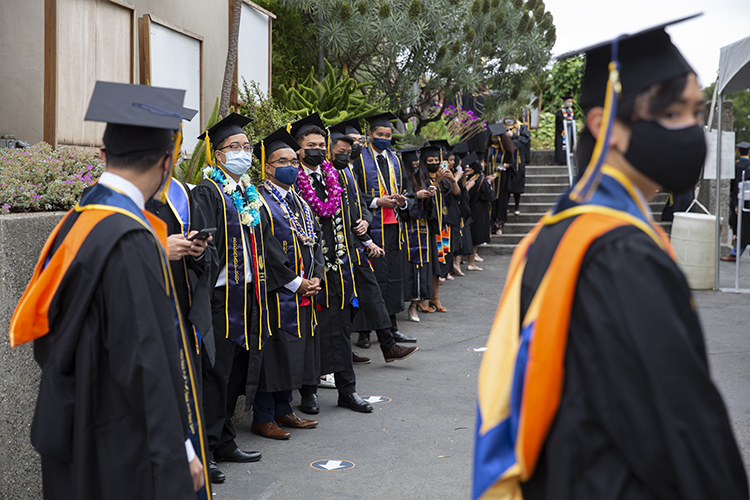 Students in brightly colored leis and stoles line up to participate in Sunday's event, the first of five days of non-stop COVID-era graduation processions at the Greek Theatre.