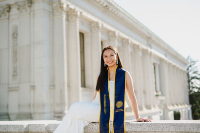Julie Thao on campus wearing graduation sash.