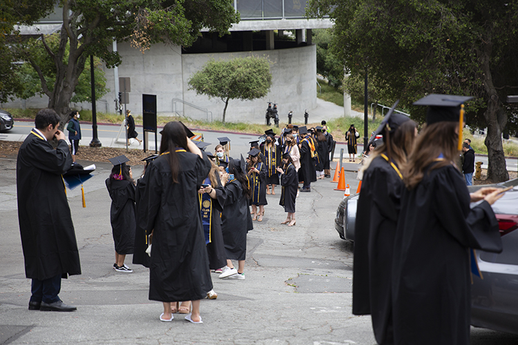 Students in regalia line up outside the Greek Theatre on the first of a five-day graduation procession during the pandemic.