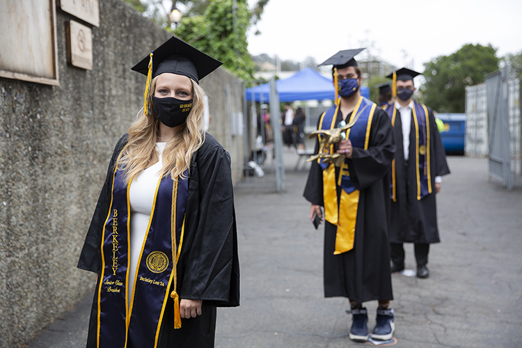 Two students prepare to cross the stage at the Greek Theatre — Senior Class Council President Megan Wiener and her friend, James Jones, who is carrying a metal eagle for 