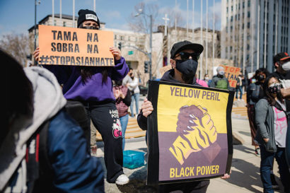 Protestors holding up a unity sigh at an anti-Asian hate protest