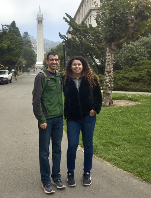 pablo aguilera and aurora lopez pose for a photo with the campanile in the background