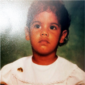 a portrait of matos as a child in front of a neutral background