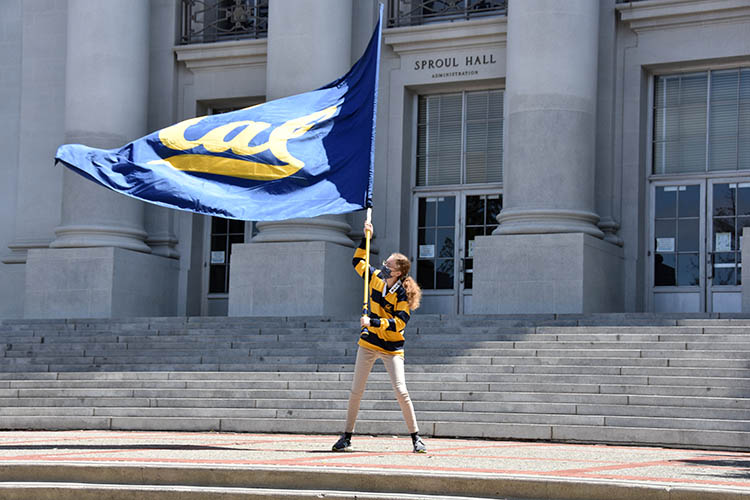 a woman waves a flag saying Cal