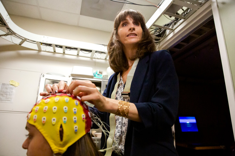 Anaïs Llorens placing EEG cap on a subject