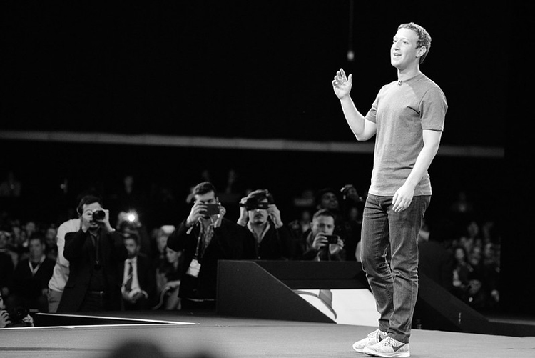 Mark Zuckerberg speaks on stage while the audience photos