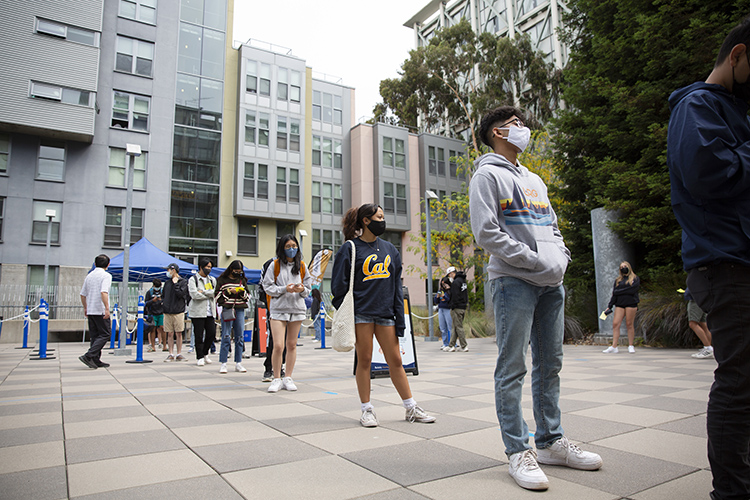 students in masks line up distant from each other