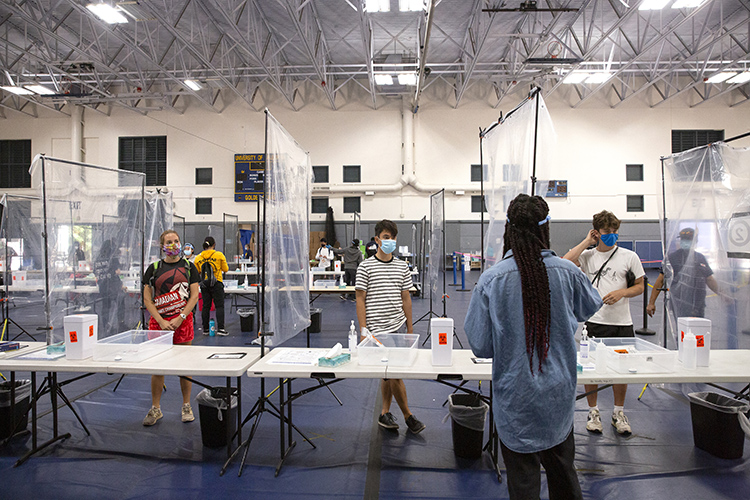 At the Rec Sports Facility, students are instructed how to swab their noses to test for COVID-19